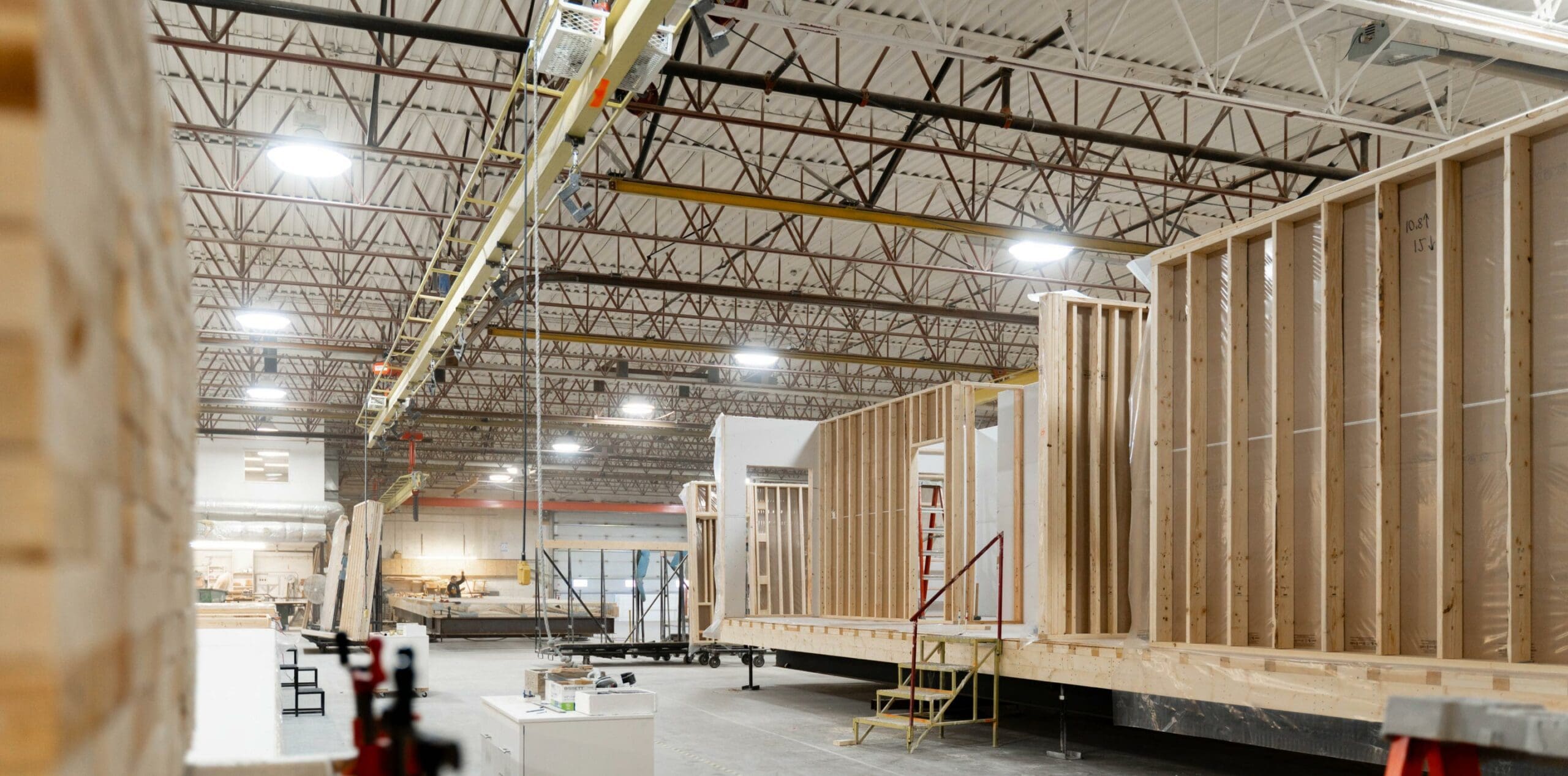 the interior of a modular housing facility that shows frames of homes in different stages of production